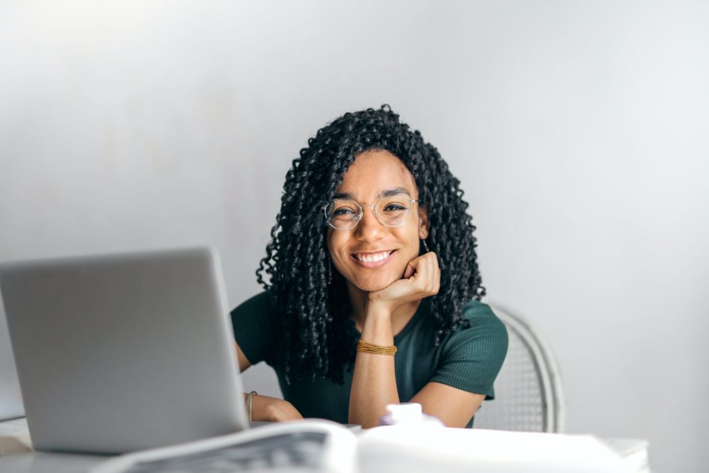 a girl is sitting next to her laptop